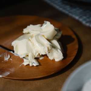 Aesthetic close-up of creamy butter on a wooden plate, perfect for culinary themes.
